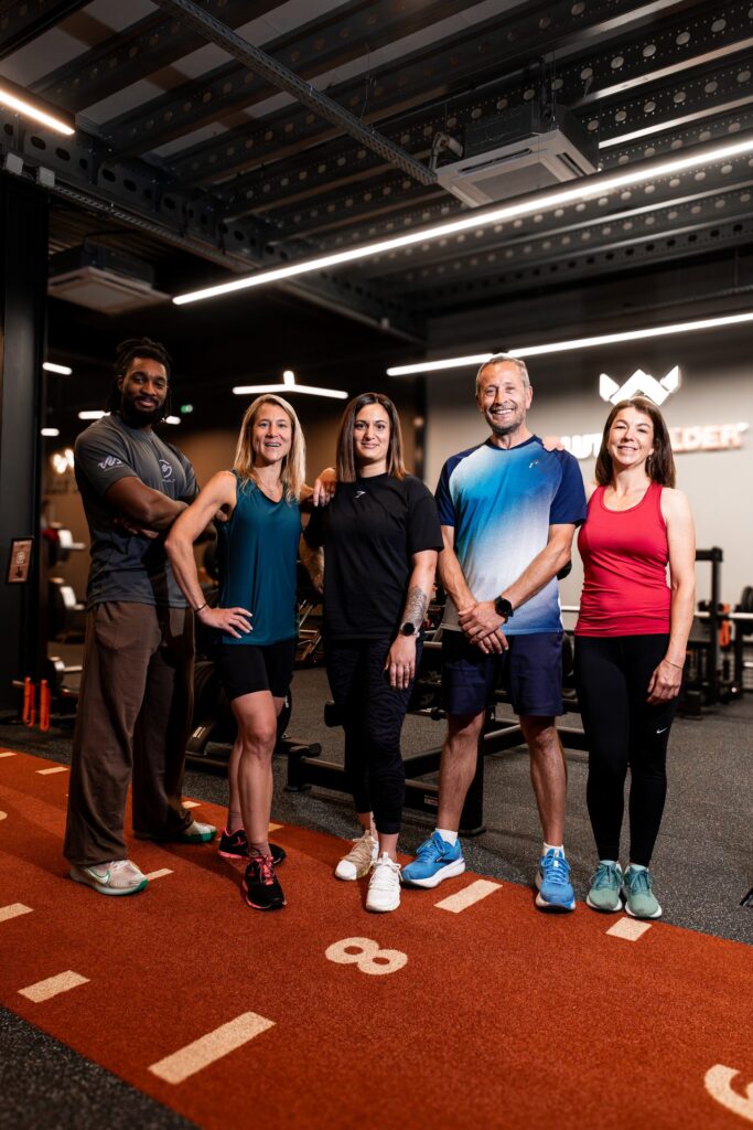 Équipe et membres Studio W posant ensemble sur la piste cross-training