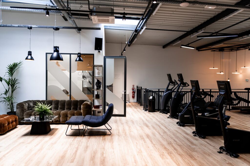 Espace détente avec canapé et zone cardio Precor à Studio W Persan